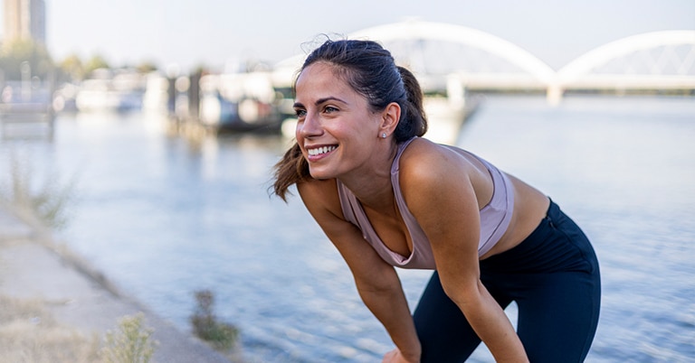 a woman standing next to a body of water